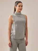 Polera color beige de tejido de punto, con cuello alto y sin mangas.