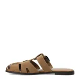 Sandalias planas de mujer Miss Carol modelo Bruna, confeccionadas en gamuza color tostado. Presentan diseño de tiras cruzadas estilo pescador, hebilla metálica de ajuste lateral y detalles de tachas en la parte superior.