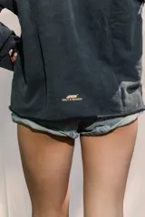 Crewneck de manga larga color gris oscuro con efecto lavado, estampado frontal con el texto "ENDLESS SUMMER" y estrellas estampadas a lo largo de las mangas.