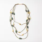 Collar de varias vueltas con cordones de gamuza verde oliva, adornado con piedras irregulares en tonos verde jaspeado y piezas metálicas doradas con forma orgánica.