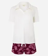 Conjunto de pijama americano corto confeccionado en viscosa. Son dos prendas: Blusa lisa color crema con manga corta, cuello polo y botones; y short color borgoña con cintura elástica y estampa floral.