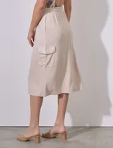 Falda midi color beige de modal, con pretina elastizada con cordón ajustable, corte recto y bolsillos cargo laterales.