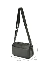 Bandolera Aurea de poliuretano símil cuero color negro, con diseño rectangular y bolsillo frontal externo. Cuenta con cierre superior y correa ajustable.