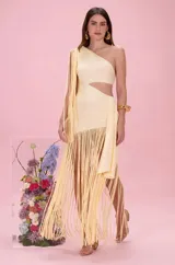 Vestido largo amarillo de un solo hombro, con diseño cut-out en el lateral de la cintura y falda asimétrica decorada con largos fleucos colgantes.