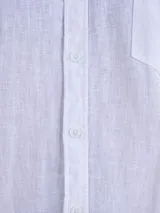 Camisa blanca de manga larga con cuello mao y cierre frontal de botones.