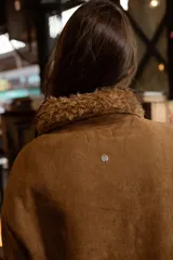 Campera de efecto gamuza color tostado con interior de corderito sintético. Presenta cierre frontal, bolsillos delanteros con solapa, cintura ajustable con cordón y puños con detalle de corderito.