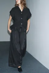 Jeans de tiro alto con diseño de pierna tipo balloon, confeccionados en denim de color gris oscuro con efecto lavado. Presentan costuras verticales marcadas a contraste, bolsillos laterales ocultos y cierre lateral con cremallera.