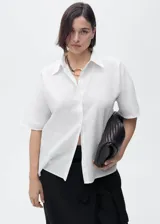 Camisa de manga corta con cuello camisero y cierre frontal de botones. Confeccionada en una mezcla de lino y algodón, presenta un diseño recto y minimalista.