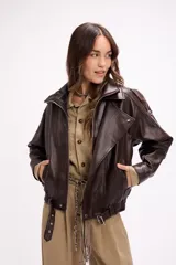 Campera estilo bomber oversize confeccionada en símil cuero negro con textura granulada. Presenta cuello alto con cierre frontal, hombreras marcadas, bolsillos laterales y cintura con elástico y cinto ajustable con hebilla metálica.