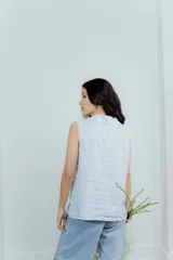 Chaleco color amarillo pastel de lino, sin mangas, con cuello solapa y cierre frontal con dos botones.