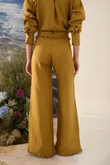 Pantalón morado de corte acampanado con volados decorativos en la cintura y en el ruedo.