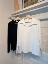 Chomba de algodón blanca con cuello camisero y cierre frontal parcial, de manga larga y calce holgado.