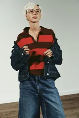 Jersey de punto a rayas horizontales en color marrón y rojo, con cuello polo y cierre frontal parcial, de manga larga y diseño holgado.