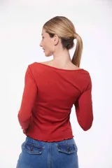 Remera de mangas largas color celeste, con cuello redondo y terminaciones con volados.