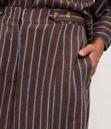Short de corte recto confeccionado en viscolino con diseño de rayas verticales, cintura trasera con elástico, tapetas frontales con botones decorativos y bolsillos laterales.