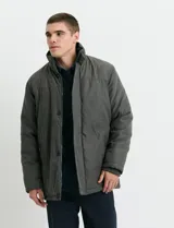 Campera de estilo Harrington en color verde oscuro, con cuello alto, cierre frontal y solapa con botones.
