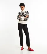 Suéter de punto con cuello alto y mangas largas, con estampado animal print de leopardo en tonos blanco, negro y marrón.