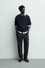 Pantalón de vestir regular fit color negro, con pliegues frontales y cierre con cremallera y botón.