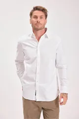 Camisa blanca de manga larga con cuello clásico y cierre frontal con botones.