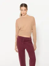 Sweater color beige de lana merino, mangas largas y cuello redondo cerrado.