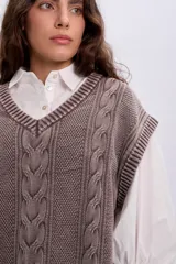 Chaleco oversize de tejido de punto color marrón, con escote en V y diseño con trenzas y textura.