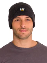 Gorro tipo beanie de punto acanalado en color gris oscuro, con vuelta en el borde y etiqueta rectangular con el logo de CAT en el frente.