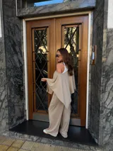 Pantalón de lanilla color beige, de corte recto y tiro alto, con diseño holgado y fluido.