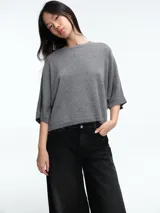 Sweater de tejido de punto color gris, con silueta relajada, mangas estilo murciélago y cuello a la base.