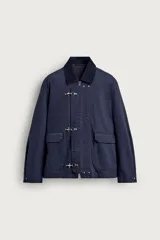 Cazadora relaxed fit de algodón azul marino con estructura canvas y acolchado interior. Cuenta con cuello solapa de pana, bolsillos de plastrón con solapa en la cadera, y cierre frontal de cremallera oculta con solapa decorada con alamares metálicos.