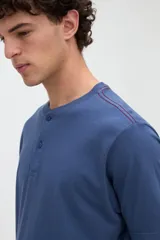 Remera de manga corta color azul con cuello redondo y media cartera de botones.