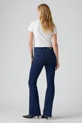 Jean de corte flare con tiro alto, confeccionado en denim azul oscuro con efecto desgastado. Presenta cierre de cremallera con botón metálico, cinco bolsillos tradicionales y costuras reforzadas.