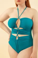 Malla entera negra con escote halter, aberturas en el abdomen y espalda descubierta.