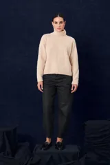 Polera de tejido suave con textura, cuello alto, mangas largas y silueta recta.