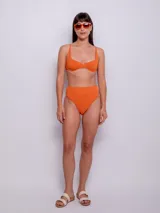 Parte inferior de bikini tiro alto color naranja, con textura de flores.