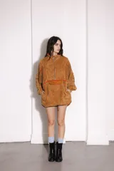 Buzo marrón de pana con cierre frontal parcial, cuello alto, bolsillo tipo canguro con solapa y cordón ajustable en el ruedo.