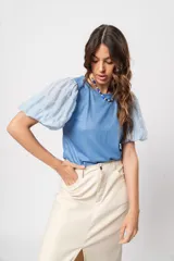 Blusa azul de cuello redondo y manga corta abullonada con puño elástico.