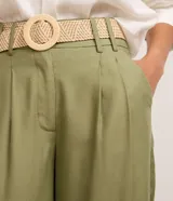 Pantalón wide leg de tiro alto color verde militar, confeccionado en mezcla de viscosa y lino, con pliegues frontales y trabillas en la cintura. Incluye un cinturón de rafia sintética con hebilla redonda.