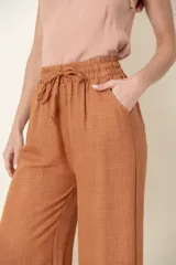 Pantalón ancho color ladrillo, de viscosa y poliéster, con cintura elastizada, cordón para ajustar y bolsillos laterales.