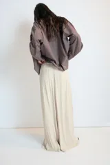 Pantalón de tiro medio, color negro, confeccionado en tejido satinado con diseño de pierna ancha y cintura elástica ajustable con cordón.