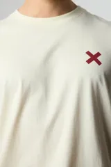 Remera color crema de manga corta con logo bordado en el pecho.