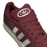 Championes adidas modelo Campus 00s, color bordó con las icónicas tres tiras laterales en blanco. Presentan una silueta clásica de perfil bajo, confeccionados en gamuza con suela de goma en tono crema.