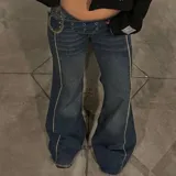 Jean tiro bajo azul de corte flared con costuras decorativas contrastantes en la parte frontal y cintura ancha con hebilla metálica grande en el lateral.