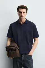 Polo de punto azul marino, de corte regular fit, con cuello solapa, abertura frontal en V y mangas cortas.