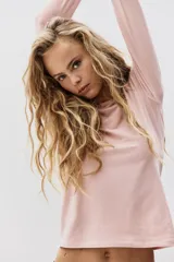 Remera de manga larga color rosa pálido, con cuello redondo y corte entallado.