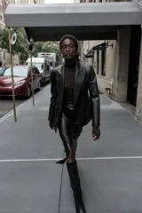 Blazer entallada de cuello solapa y manga larga con hombreras, confeccionada en efecto piel color negro. Cuenta con bolsillos delanteros con solapa y cierre frontal cruzado con botones.