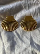 Par de aros tipo caravanas con forma de concha marina, color dorado, hechos de acero inoxidable.