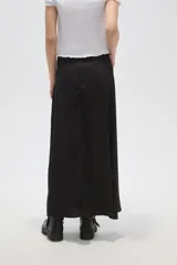 Falda larga de corte recto y tiro alto, confeccionada en poliéster de color negro con acabado satinado.