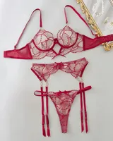 Conjunto de lencería de tres piezas en color rojo, confeccionado en tela transparente con bordados ornamentales. Incluye soutiene con aro y tirantes ajustables, bombacha colaless y portaligas a juego con detalles de argollas y apliques.