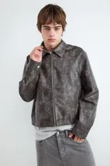 Campera de cuero sintético efecto gamuzado, color negro, con cuello camisero y cierre frontal metálico.