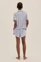 Conjunto de short y camisa de toalla color lila. El short tiene cintura elastizada con cordón regulable y bolsillos laterales.